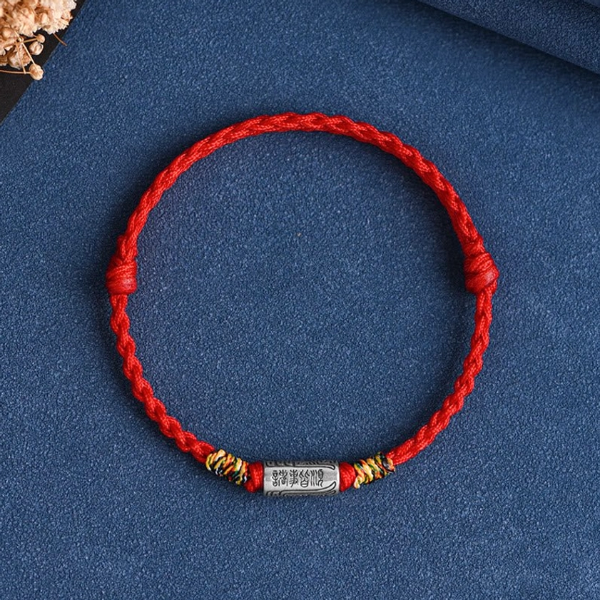 Front view of sterling silver Buddhist bracelet with engraved everything goes well design, red braided rope with silver tube charm detail