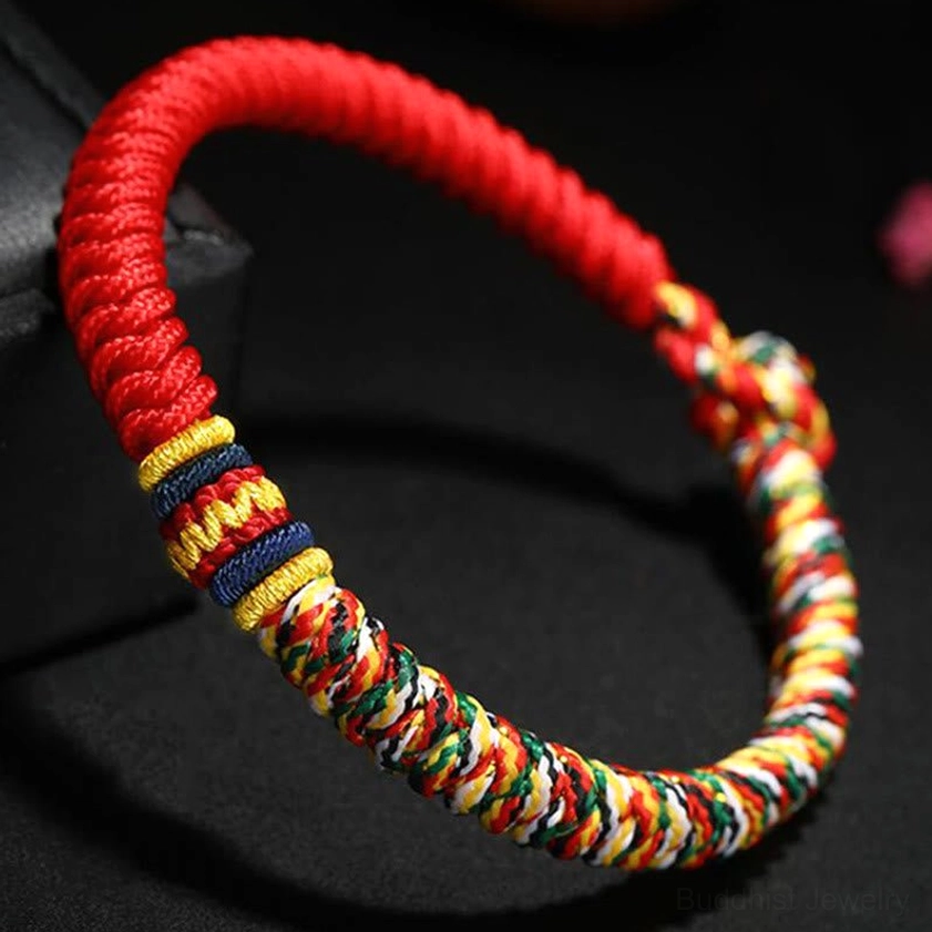 Thick woven red Buddhist braided string bracelet with colorful woven segments showing King Kong Knot craftsmanship and detailed texture