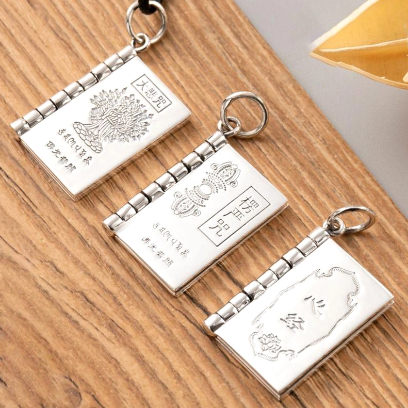 Three Buddhist mantra silver pendant styles including Heart Sutra, Great Compassion, and Shurangama Mantra with hinged book design