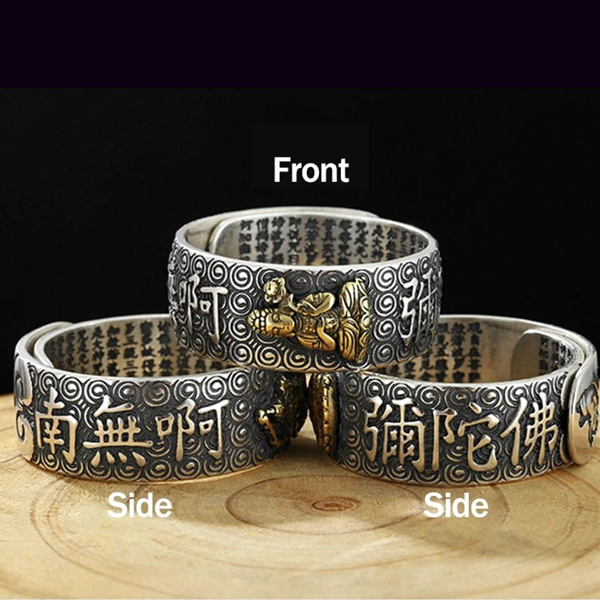 Adjustable Buddha sutra ring showing multiple styles with engraved sutras, Buddha statue, and Namo Amitabha lettering in vintage silver and gold tones on wooden table