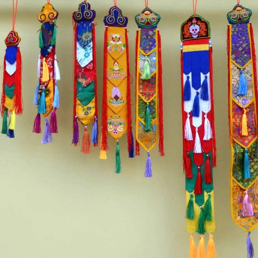 Matching collection of Buddhist symbol wall hangings with varied embroidered patterns and silk tassels