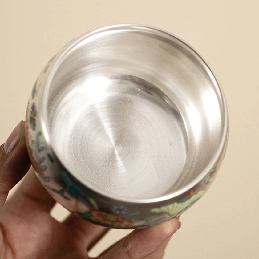 Interior smooth silver enamel finish of Buddhist ceramic tea cup, top-down view showing pristine brushed surface