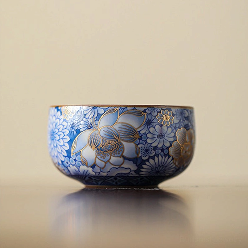 Handcrafted Buddhist porcelain teacup with hand-painted gold floral patterns front flat view