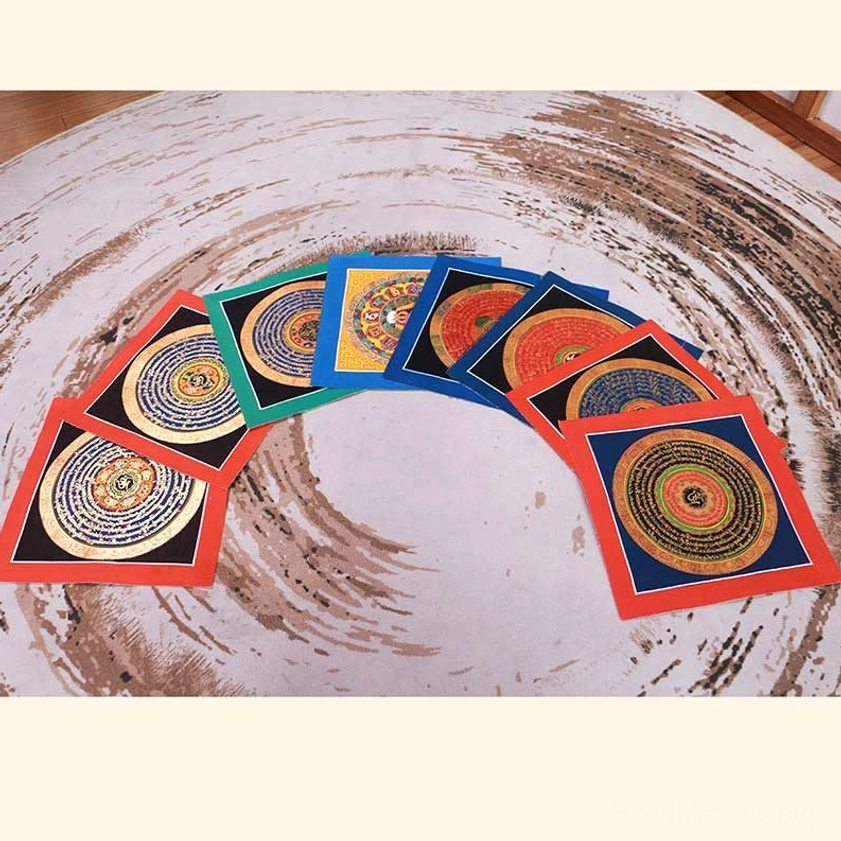 Multiple fan-arranged handmade Buddhist thangka paintings displaying various mandala designs and colored borders