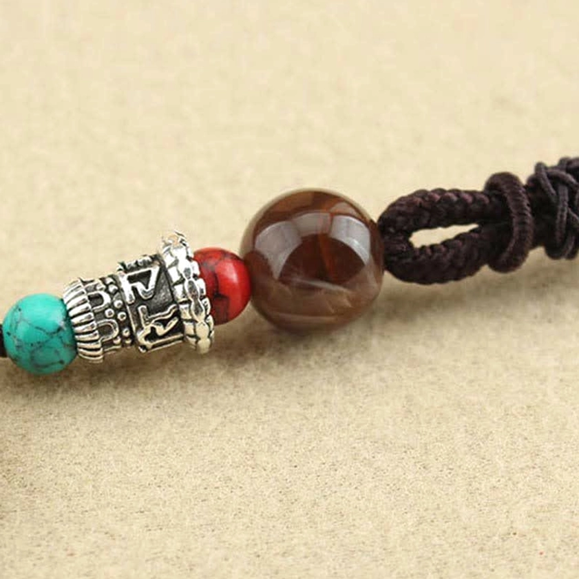Buddhist Thangka ebony pendant necklace artistic photography, capturing spiritual essence of Five Gods of Wealth with warm lighting