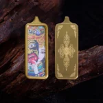 Double-sided Buddhist thangka pendant necklace with gold metal frames and folk deity artwork, flat lay on dark wood backdrop