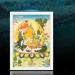 Hand-painted Buddhist thangka scroll in white frame displayed on dark background, full frontal view of traditional deity artwork with vibrant colors and intricate mandala designs
