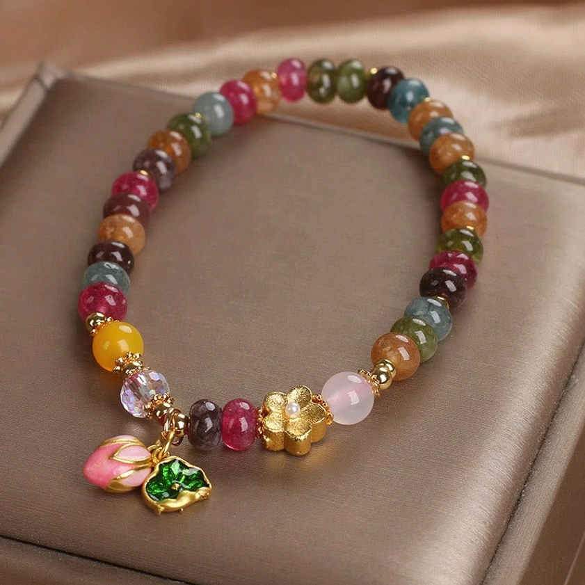 Buddhist tourmaline lotus bracelet with natural multicolor stones, gold accents, and pink lotus seedpod spiritual charm