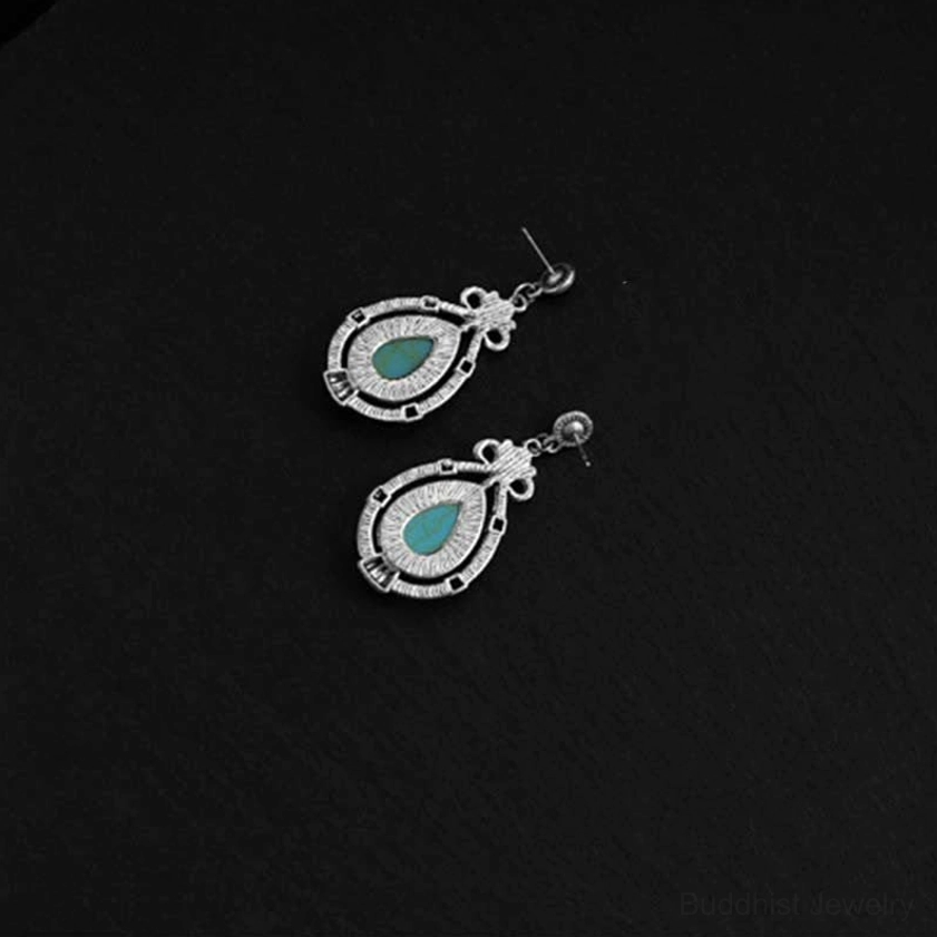 Handmade turquoise Buddhist earrings showing authentic natural stone variations and vintage design elements