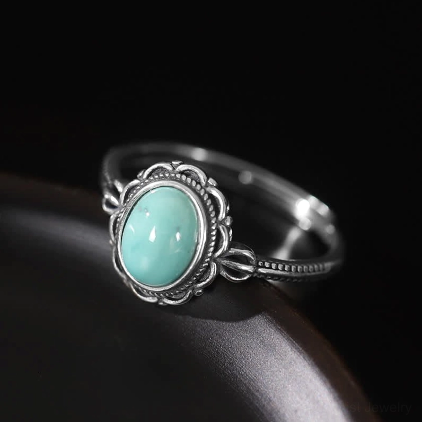 Side view of turquoise Buddhist protection ring showing twisted decorative silver band detail