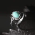 925 sterling silver Buddhist turquoise ring with ornate filigree bezel setting, sparkly dark background
