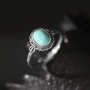 925 sterling silver Buddhist turquoise ring with ornate filigree bezel setting, sparkly dark background