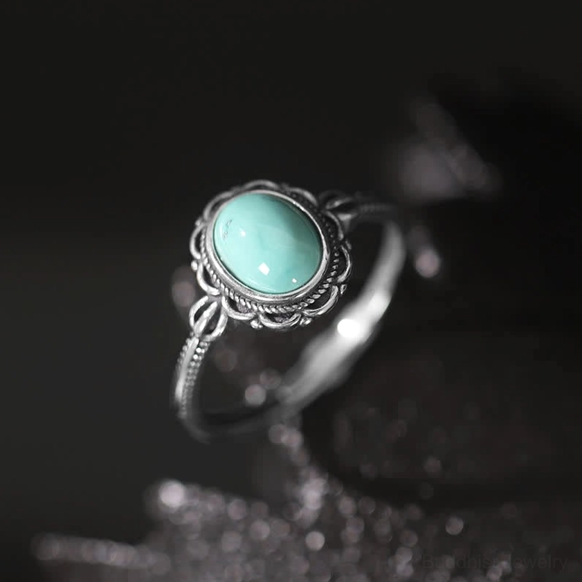 925 sterling silver Buddhist turquoise ring with ornate filigree bezel setting, sparkly dark background