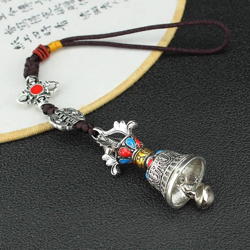 Front flat view of silver Vajra bell car hanging with cross Vajra charm and colored enamel decorations on braided rope