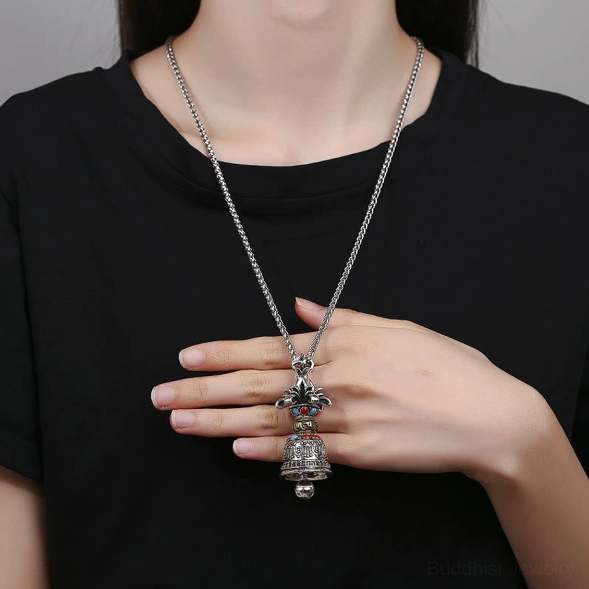 Worn Buddhist Vajra Bell pendant necklace on body with long silver chain paired with casual black clothing