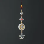 Buddhist vajra car hanging ornament with five-pronged design, silver metal finish, colorful braided cords and faux gemstones - top-down view