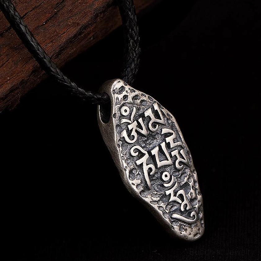 Buddhist mantra silver pendant with Vajra symbol close-up, showing handcrafted engraving quality and vintage finish