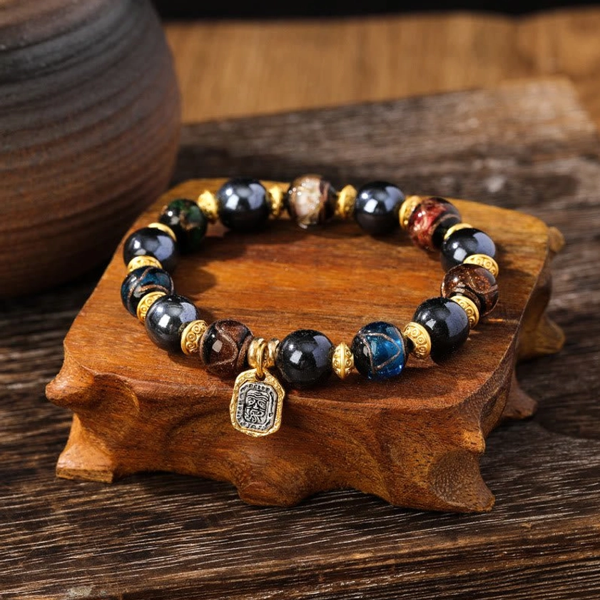 Blue multicolored Liuli glass Buddhist wealth bracelet with shimmering beads and engraved square prosperity pendant