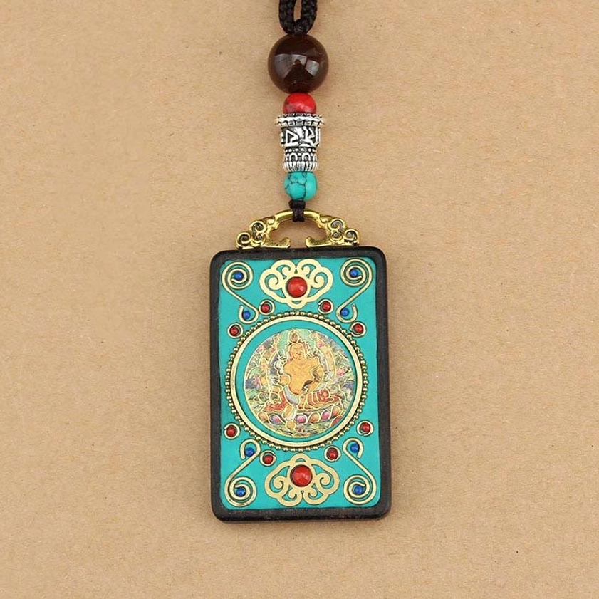 Buddhist wealth thangka necklace pendant with adjustable braided cord on tan background