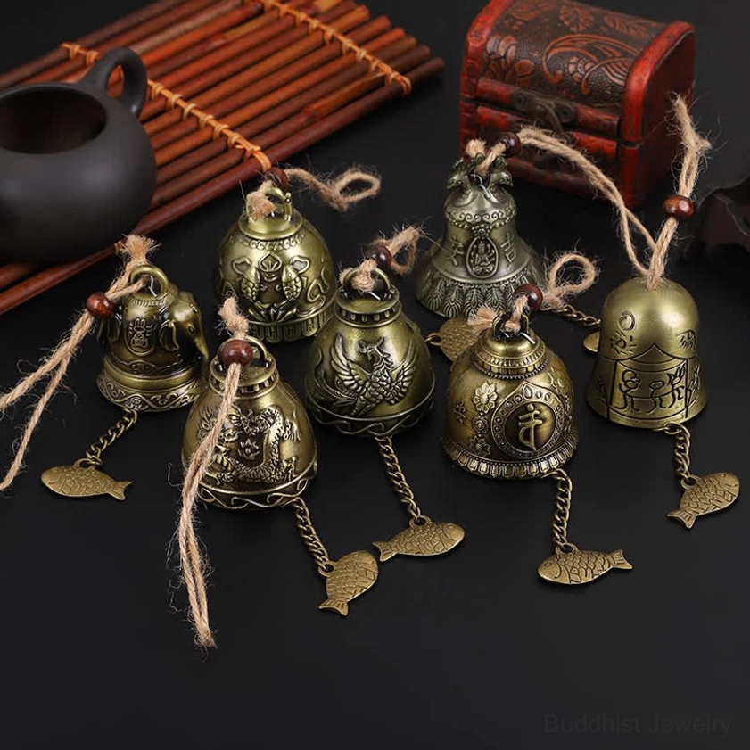 Antique bronze Buddhist wind chime bell with carved fish pendant on Chinese style tea set display