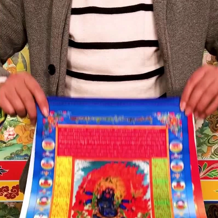 Close-up hands unfolding Buddhist windhorse prayer flag with sacred mantra printing vibrant colors