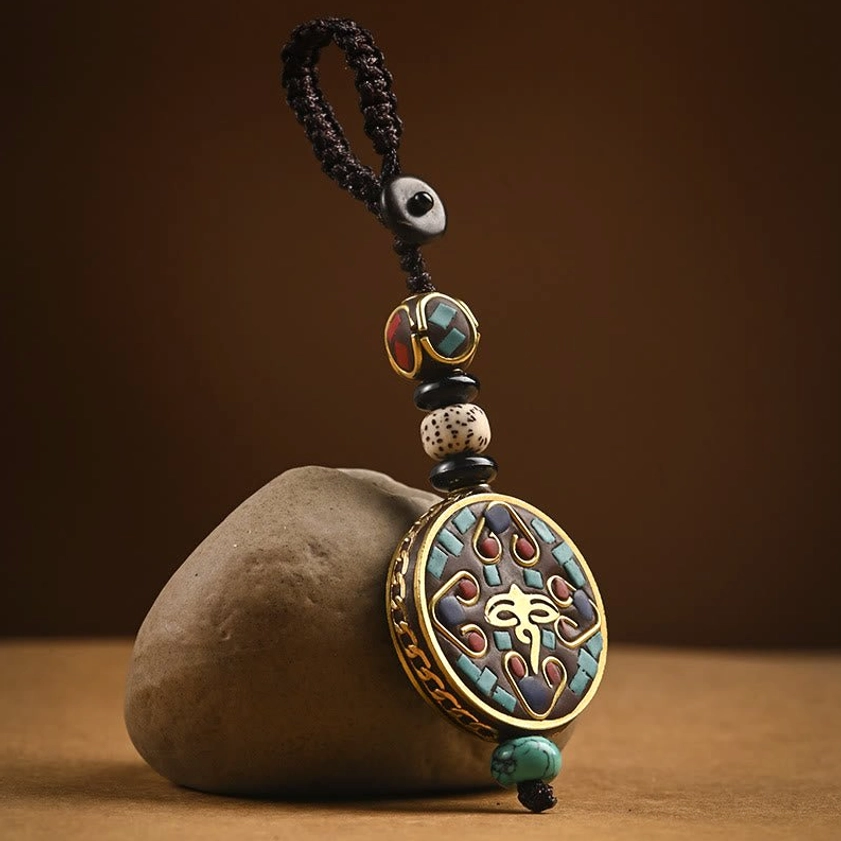 Tibetan Buddhist Wisdom Eye pattern keychain charm with enamel brass pendant on vintage desktop