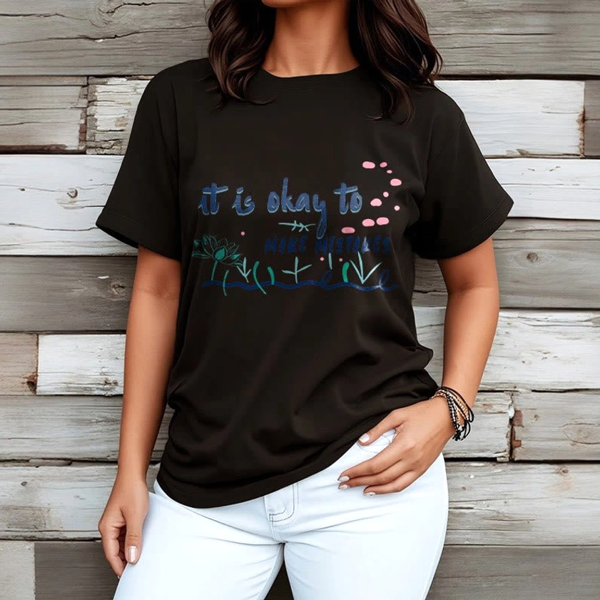 Female wearing black Buddhist mindfulness tee with white pants wooden wall backdrop