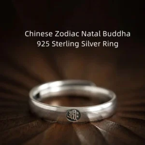 925 sterling silver Buddhist zodiac natal buddha couple ring with embossed zodiac symbol, overhead view on dark wood backdrop