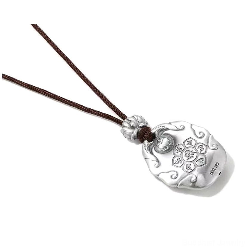 Back of Buddhist Buddha head silver pendant showing six-syllable Om Mani Padme Hum mantra engraving, matte silver finish, lotus buckle, and brown cord