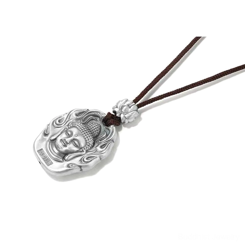 Buddhist Buddha head silver pendant side top-down angle on white background, matte silver material, brown cord, lotus decoration, and flame pattern frame