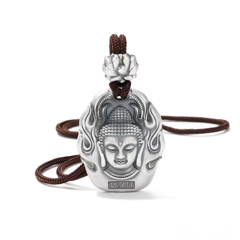 Buddhist Tathagata Buddha head pendant on white background, matte silver with lotus top ornament, brown hanging rope, and bottom Chinese inscription