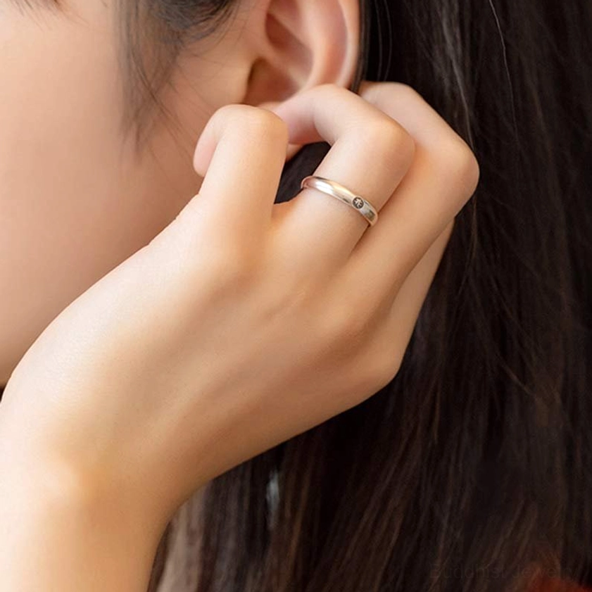 Slim sterling silver Buddhist zodiac ring worn on hand, close-up side view with zodiac symbol