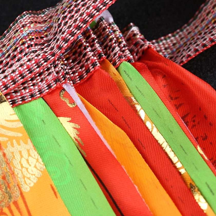 Bundled Buddhist prayer flags with checkered hanging straps showing red and green color tones