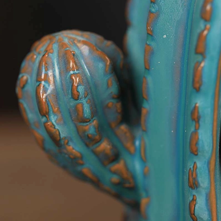 Side close-up of cactus pad texture showing glazed ceramic with bronze trim and realistic spine detailing