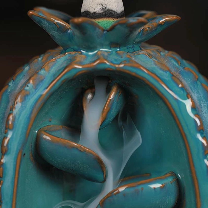 Close-up overhead view of cactus incense burner top with lotus-shaped cap and backflow smoke cascade detail