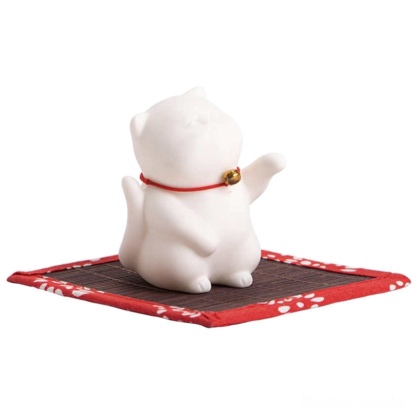 Isolated product shot of matte white ceramic cat incense holder with red collar on tatami mat coaster against neutral background