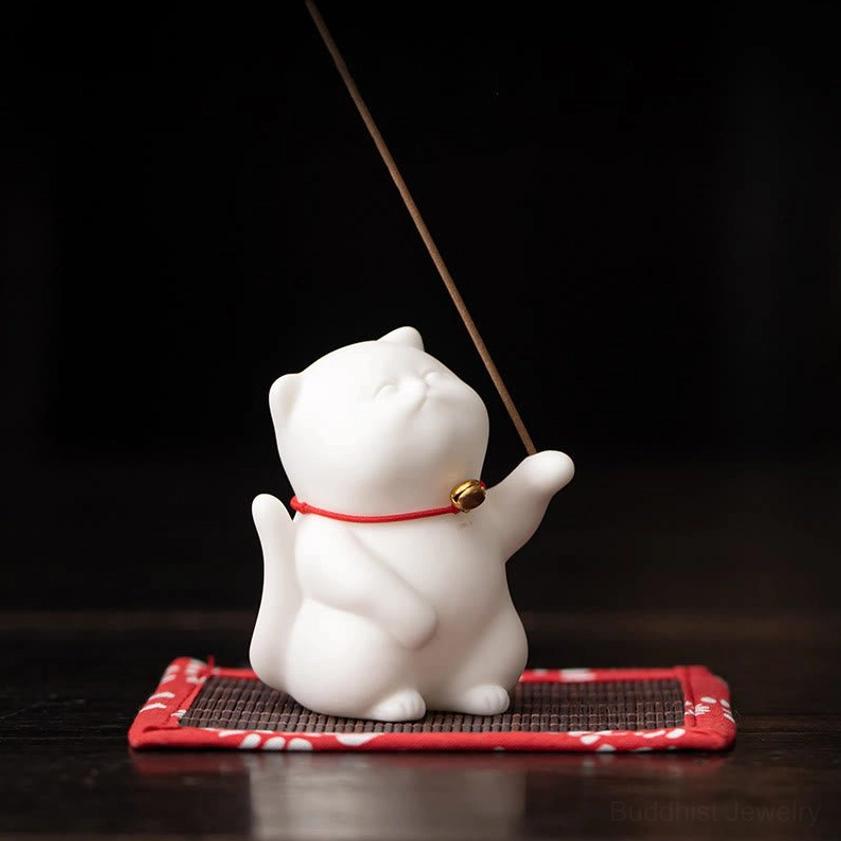 Side three-quarter view of handcrafted ceramic cat incense holder on dark wood table showing profile and incense stick placement for spiritual practice