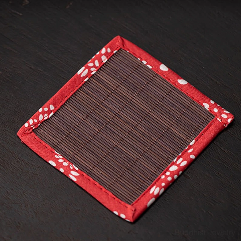 White ceramic lucky cat incense burner with red-trimmed mat showing traditional Buddhist altar arrangement