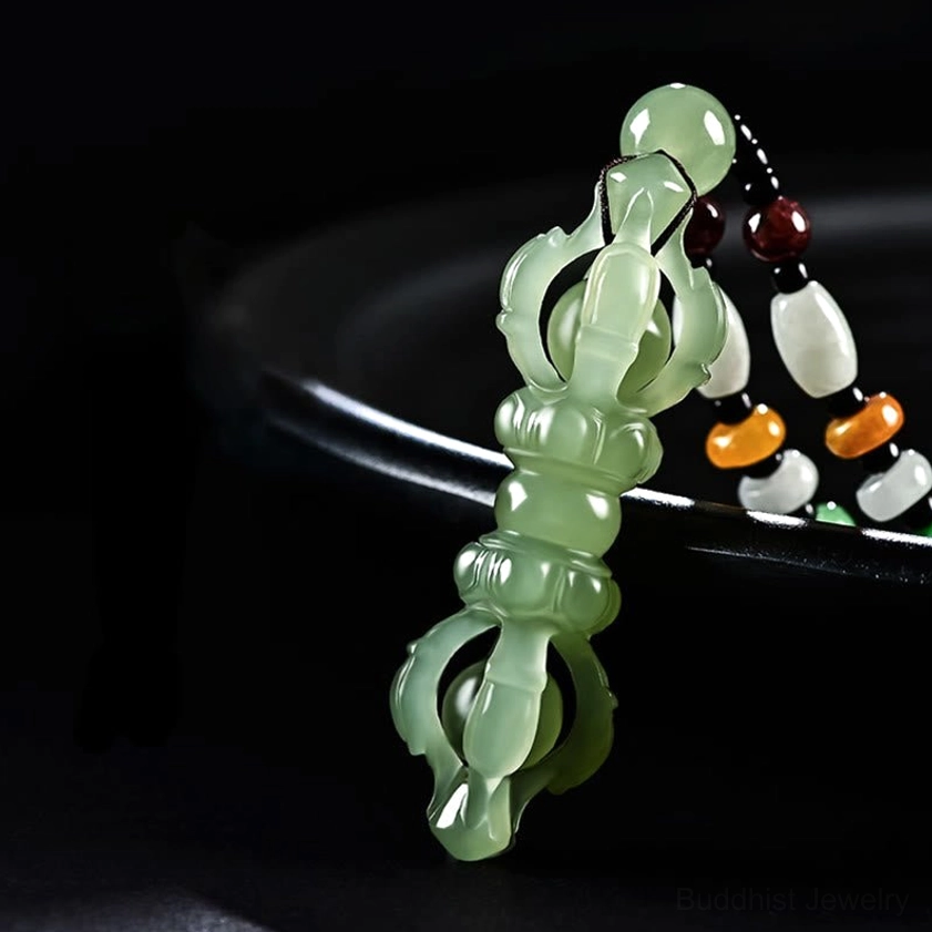 Celadon Hetian jade Dorje Vajra pendant necklace upper side perspective on black ceramic plate, clear hollow carved design