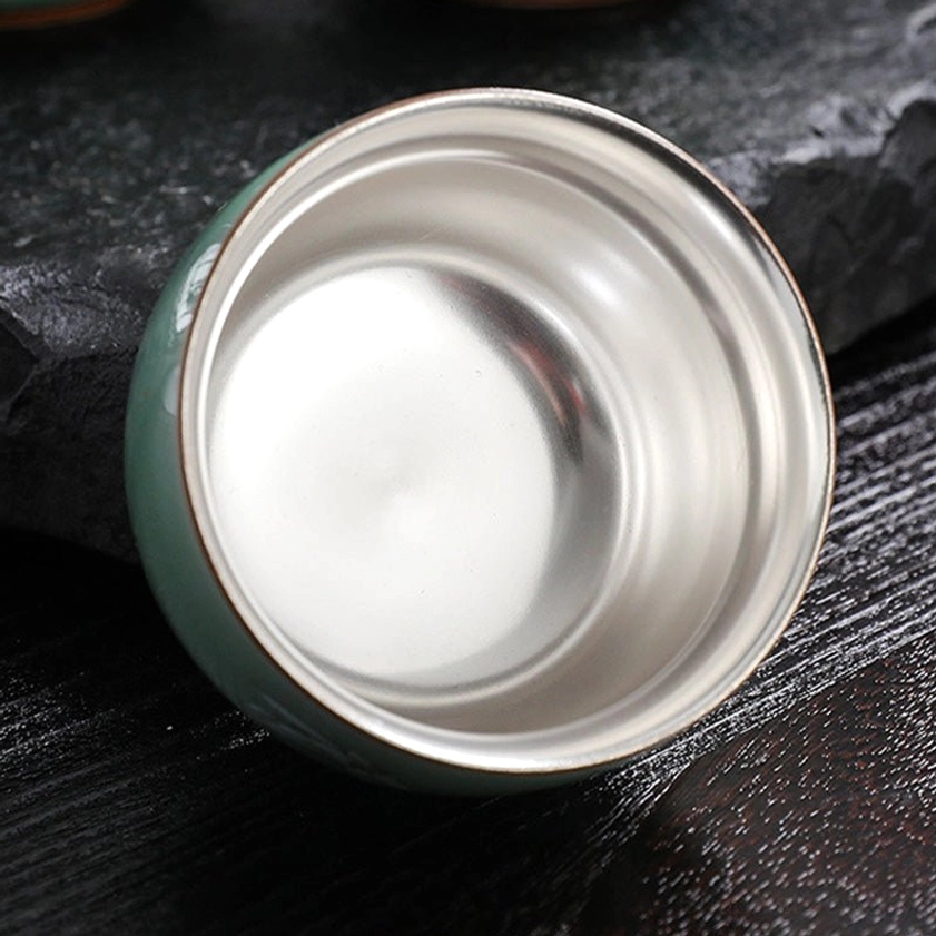 Artisan-crafted celadon tea cup showing silver gilding technique applied to interior for authentic Buddhist tea ceremony