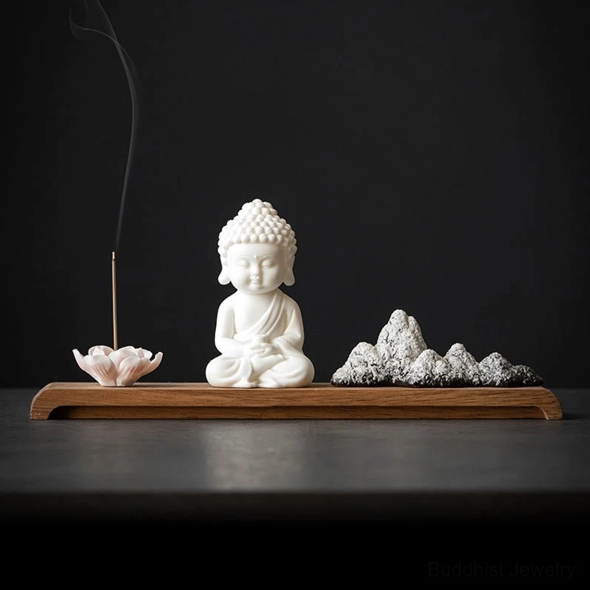 Front view of white ceramic Buddha incense holder with pink lotus design and mountain stone decorations