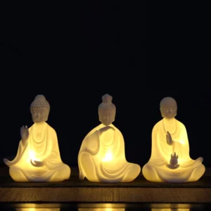 Ceramic Buddha LED decoration set with multiple handcrafted bodhisattva statues showing warm LED light on dark wooden display table