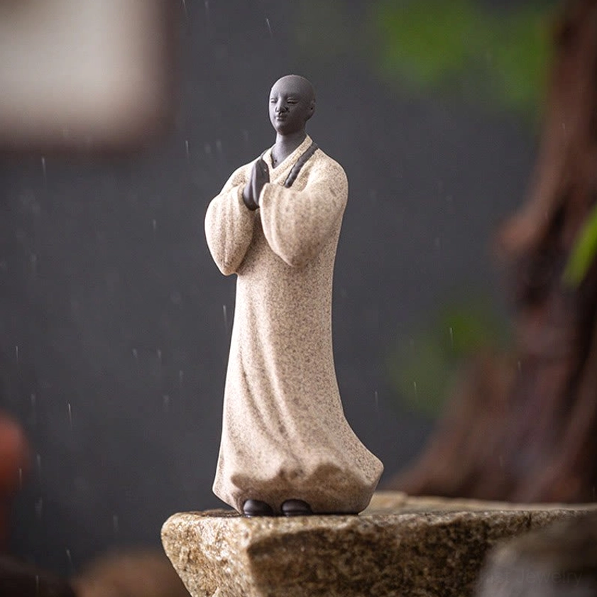 Handcrafted ceramic Buddhist monk figurine displayed in peaceful home environment promoting inner peace and tranquility