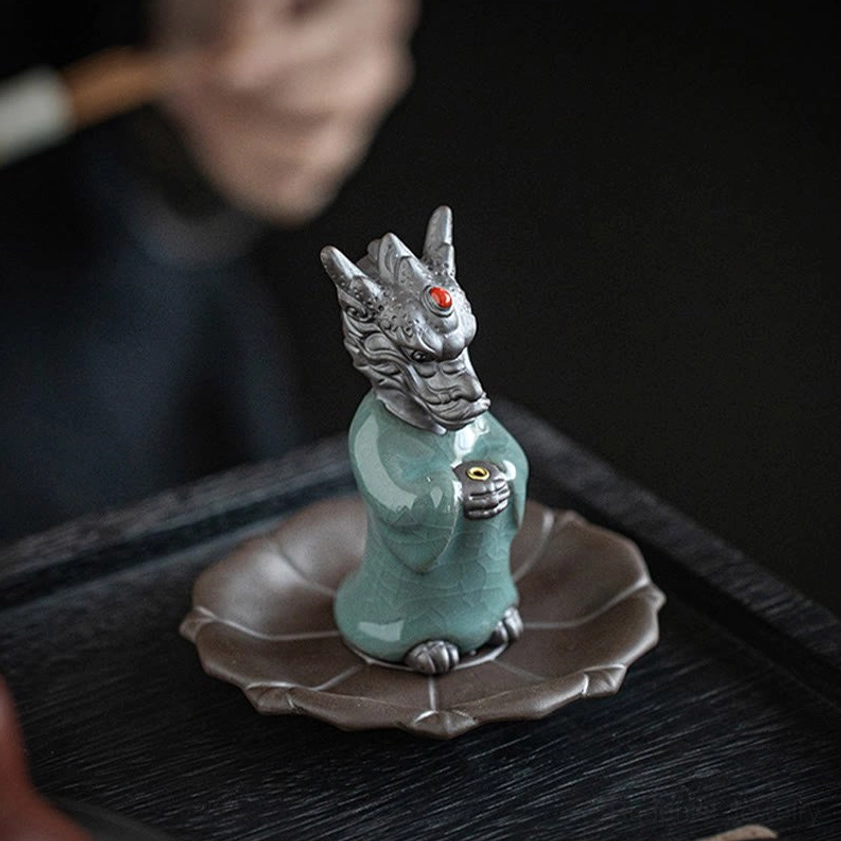 Dragon incense burner close-up on lotus tray with red forehead gem, crackle glaze texture, and smoking incense stick
