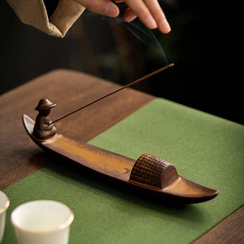 Handmade ceramic fisherman boat incense burner with incense cone burning showing smoke