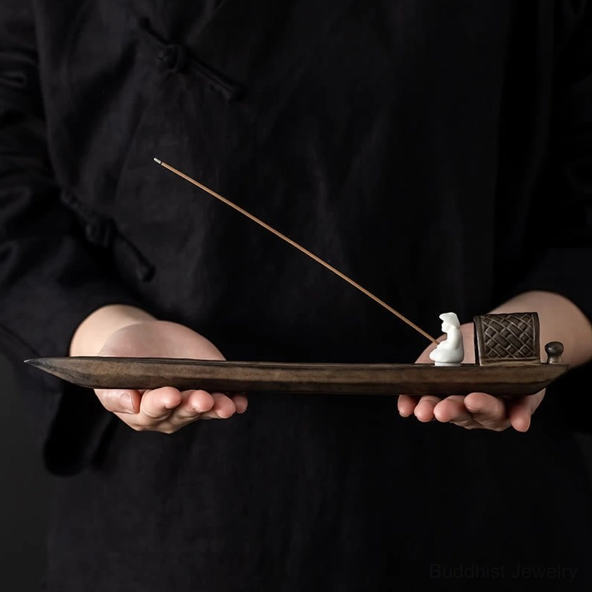 Handheld view of handcrafted ceramic fishing boat incense burner showing form and incense mounting