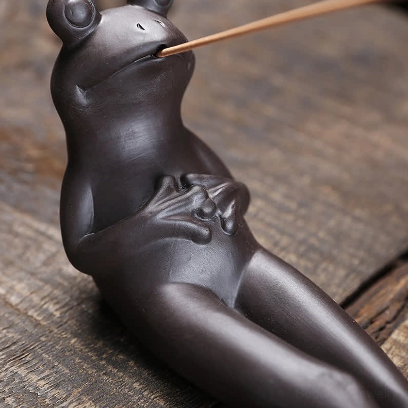 Close-up front view of ceramic frog incense burner showing facial features and fine hand details