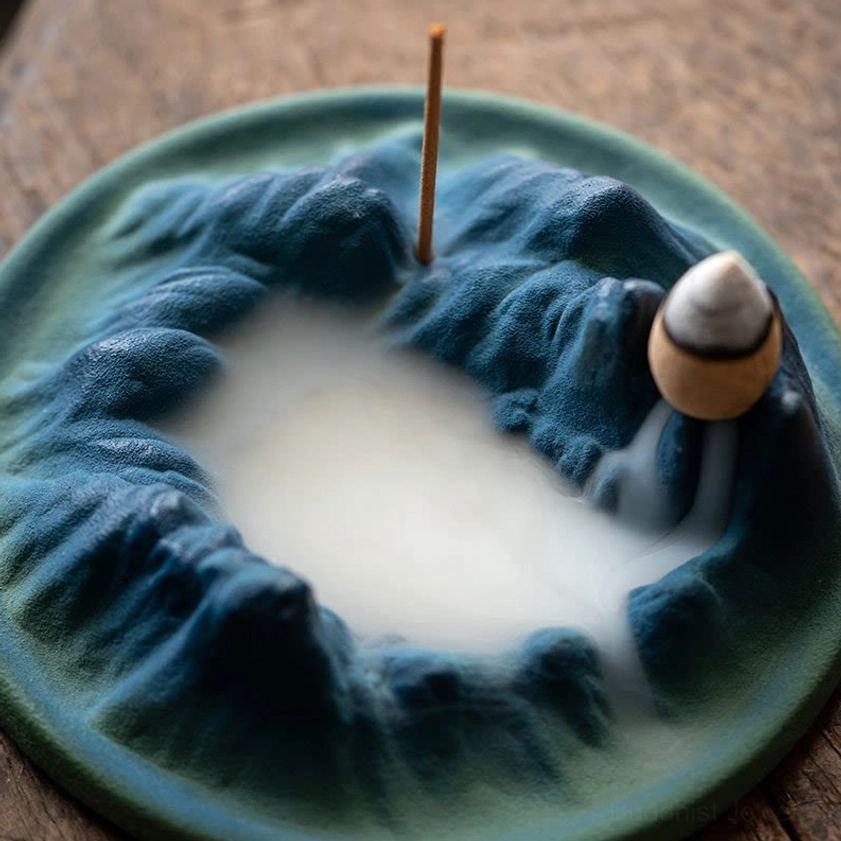 Close-up overhead view of handcrafted ceramic incense burner showing frosted texture and backflow smoke pooling in crater effect