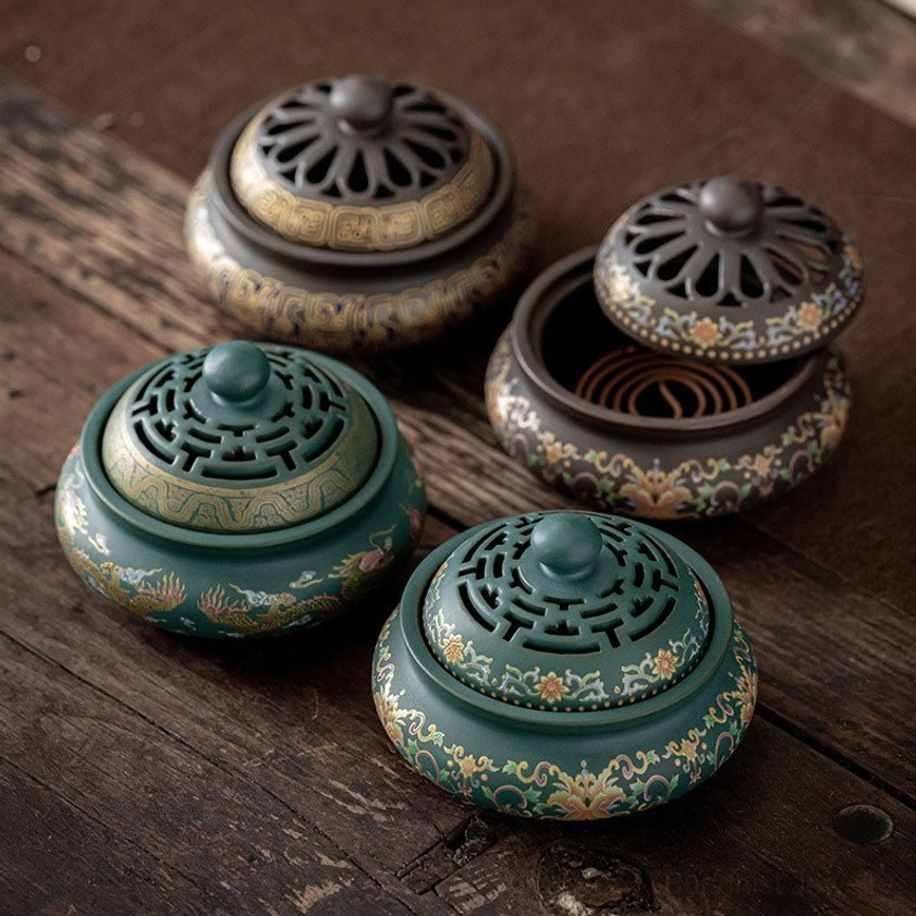Multiple ceramic incense burner variants displayed together showing different color options and cloisonne style floral patterns