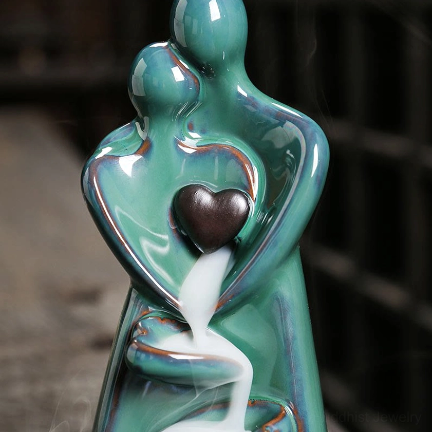 Detailed front view of turquoise ceramic couple embrace incense holder with flowing smoke